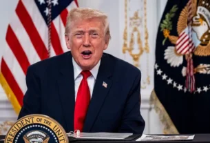 "Ex-presidente dos Estados Unidos, Donald Trump, discursando atrás de podio com selo presidencial e bandeiras dos EUA ao fundo."