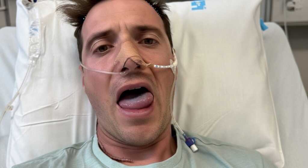 "Paciente internado em hospital com inchaço severo na região da mandíbula e tubos de oxigênio nasal."