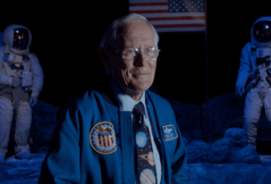 "Homem idoso usando jaqueta da NASA em cenário espacial com astronautas ao fundo e bandeira dos Estados Unidos."